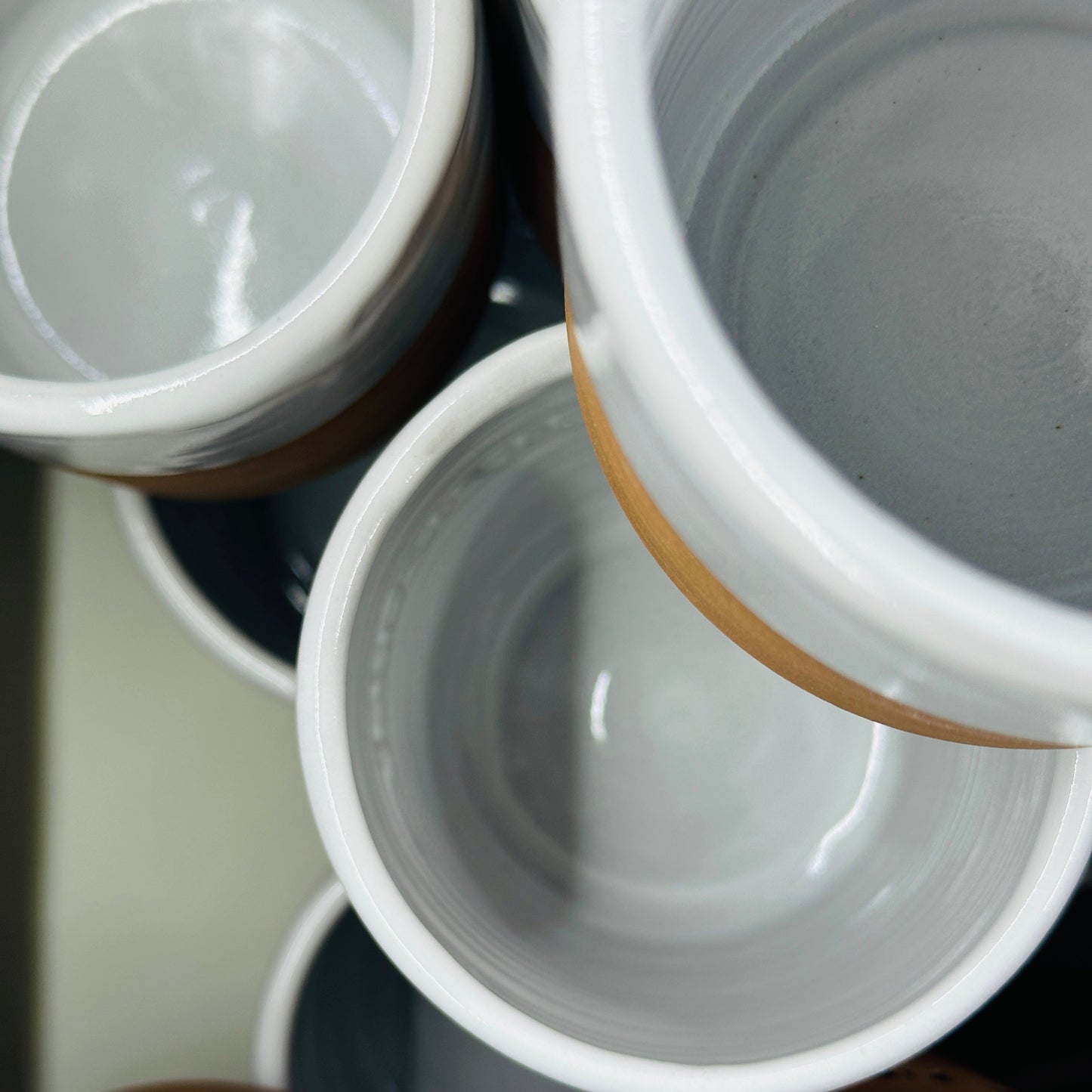 Close-up of ceramic pots with brown bases and white tops.